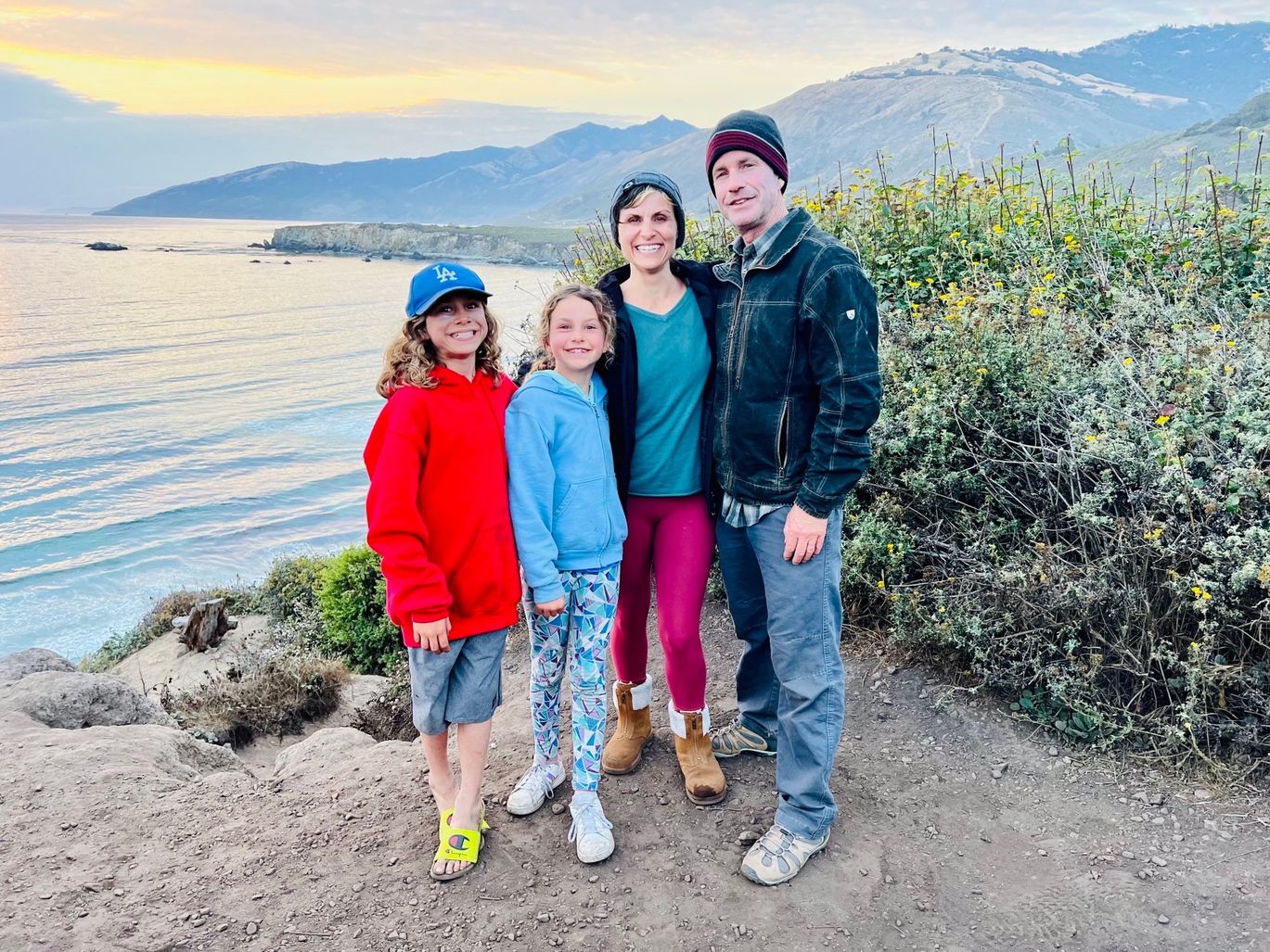 A family posing for a picture near the water.